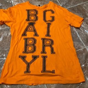 An orange Fashion Nova babygirl shirt.